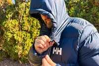 A person cinches the hood of the Helly Hansen Men