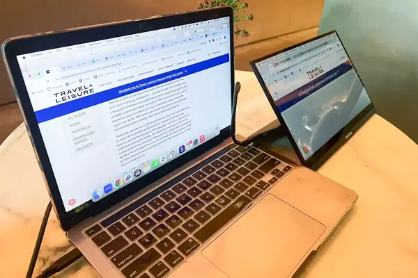 The SideTrak Solo Pro Touch FHD 13.3 next to a laptop sitting on a cafe table