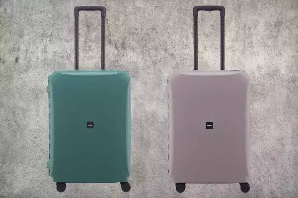 Lojel Voja Medium Warm Suitcase in Seaweed and Warm Gray on a concrete background