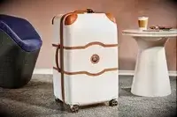 Delsey Paris Chatelet Air 2.0 26 Inch Trunk on a rug next to furniture