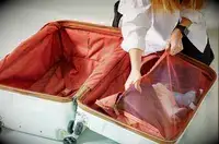 A person adding items into the Delsey Paris Chatelet Air 2.0 26 Inch Trunk