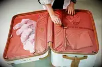 Two hands zipping a compartment of the Delsey Paris Chatelet Air 2.0 26 Inch Trunk