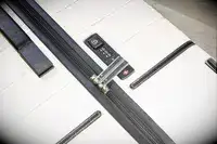 A close-up of the lock on the Travelpro x Travel & Lanetrek Large Check-In Trunk Spinner