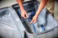 Two hands holding the strap inside of the Delsey Paris Cruise 3.0 26 Inch Trunk