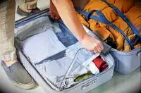 A hand zippering a compartment inside of the Delsey Paris Cruise 3.0 26 Inch Trunk