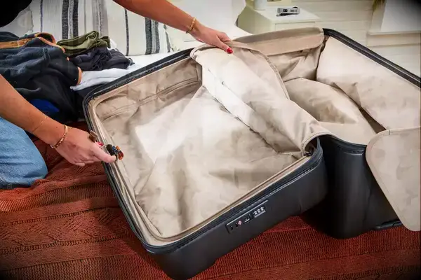 Two hands holding an empty Briggs & Riley Extra Large Trunk Spinner