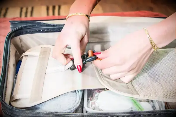 Two hands holding the strap on the Briggs & Riley Extra Large Trunk Spinner