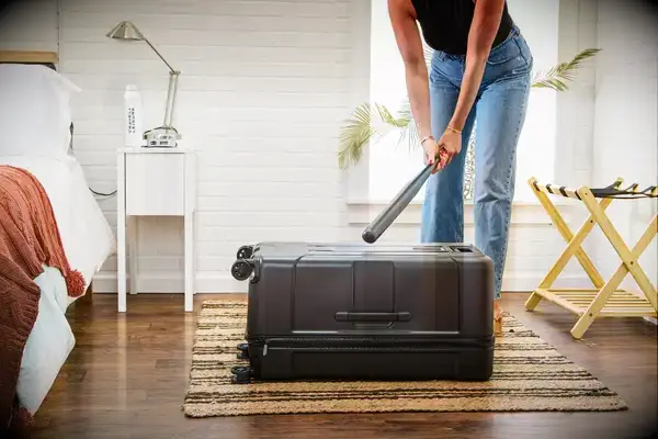 A person hitting the Briggs & Riley Extra Large Trunk Spinner with a bat