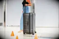 A person wheeling the Briggs & Riley Extra Large Trunk Spinner