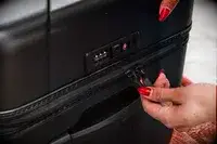 Two hands holding the zippers of the Briggs & Riley Extra Large Trunk Spinner