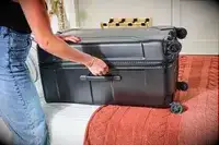 A person closing the Briggs & Riley Extra Large Trunk Spinner