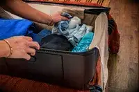 A person placing items into the Briggs & Riley Extra Large Trunk Spinner