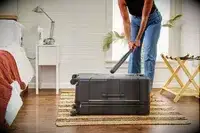 A person hitting the Briggs & Riley Extra Large Trunk Spinner with a bat