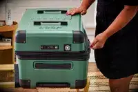 A person zips the Delsey X Jeep JH002B Large Expandable Spinner Trunk closed