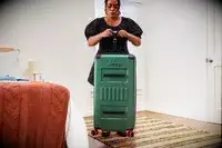 A person weighs the Delsey X Jeep JH002B Large Expandable Spinner Trunk