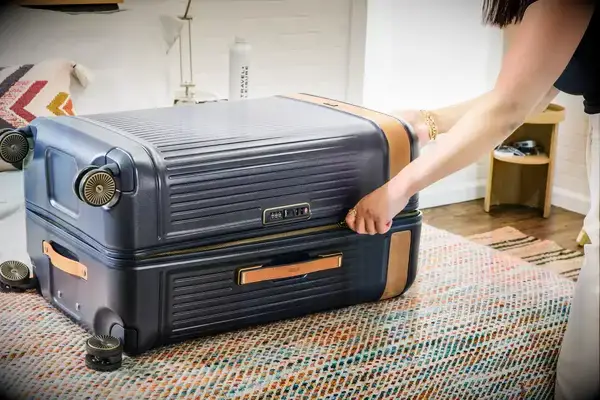 A person unzips the Hartmann Reserve Medium Expandable Trunk