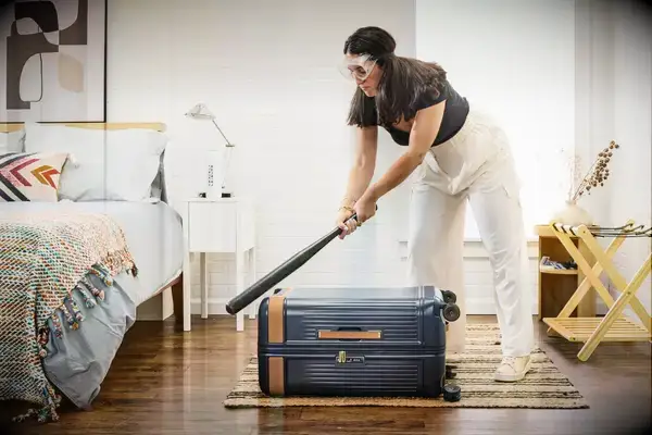 A person hits the Hartmann Reserve Medium Expandable Trunk with a baseball bat