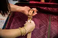 A person adjusts the strap on the Hartmann Reserve Medium Expandable Trunk