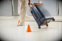 A person wheels the Hartmann Reserve Medium Expandable Trunk between cones