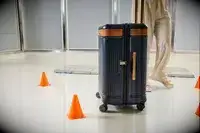 A person wheels the Hartmann Reserve Medium Expandable Trunk between cones