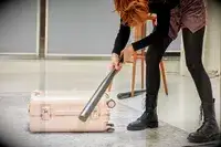 Person hitting the July Carry On Trunk with a bat