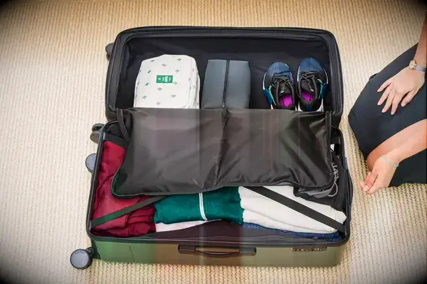 A person packs the Calpak Hue Trunk Luggage