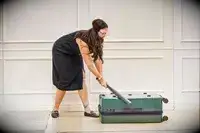 A person hits the Calpak Hue Trunk Luggage with a bat