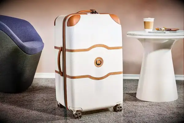 Delsey Paris Chatelet Air 2.0 26 Inch Trunk on a rug next to furniture