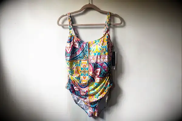 The La Blanca Island Goddess Lingerie One-Piece Swimsuit hangs on a hanger