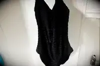 The wet La Blanca Island Goddess Lingerie One-Piece Swimsuit hangs in a shower