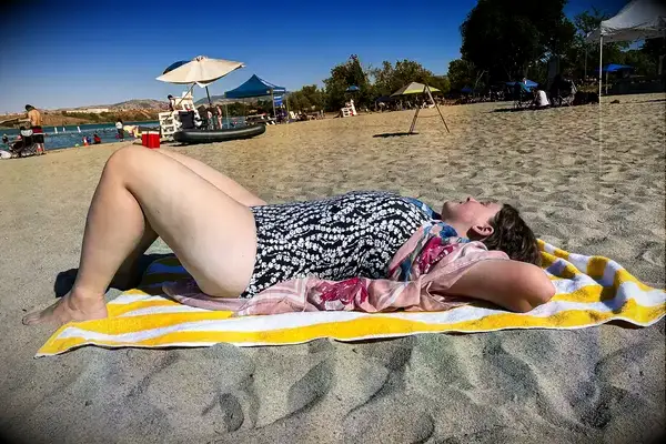 A person lays on a beach towel while wearing the Lands’ End Women