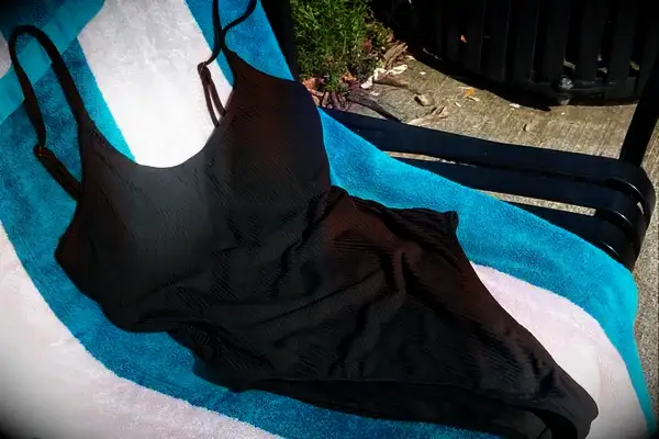 Andie The Amalfi displayed on a striped beach towel