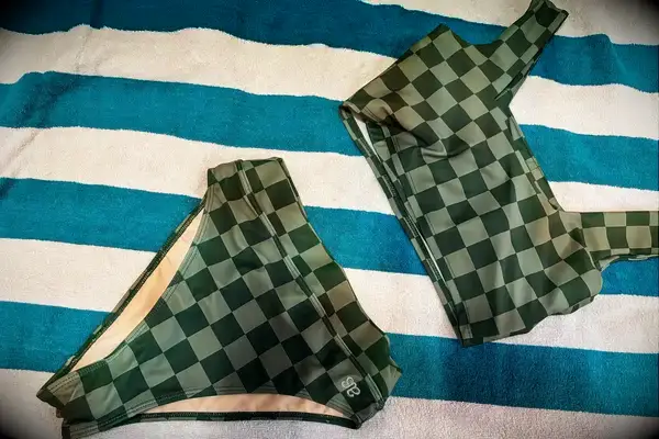 The Albion Olivia Swim Crop Swimsuit Top and Albion Almost Cheeky Swimwear Bottoms on a towel