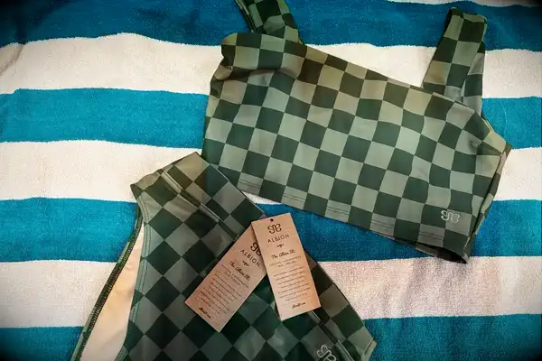 The Albion Olivia Swim Crop Swimsuit Top and Albion Almost Cheeky Bottoms on a towel