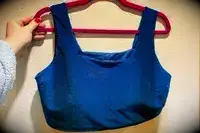 The Albion Olivia Swim Crop Swimsuit Top hangs from a hanger