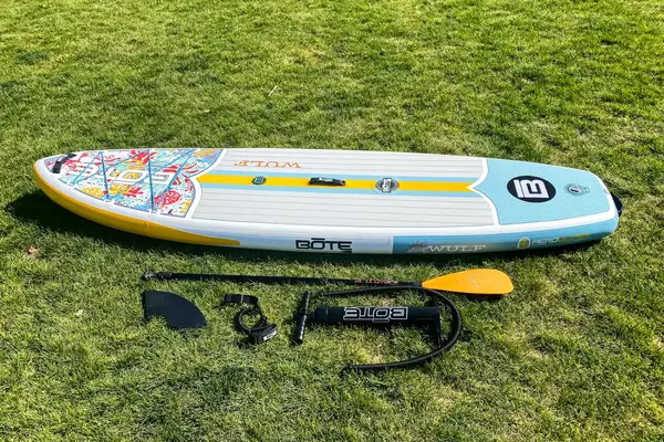 The Bōte WULF Aero Inflatable Paddle Board and its parts on grass