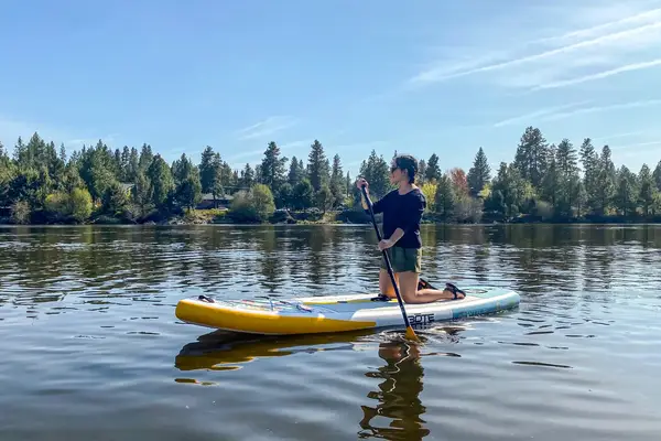 A person using the Bōte WULF Aero Inflatable Paddle Board on a lake