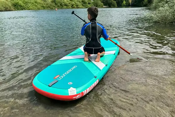 A child on the Pelican Inflatable Loungeboard with Paddle