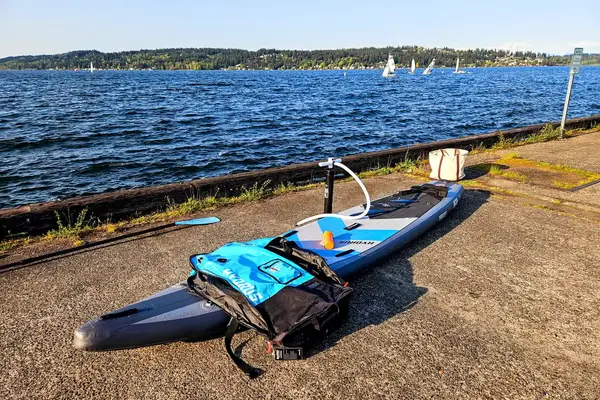 The Hydrus Paradise Touring Inflatable Paddle Board on concrete near water
