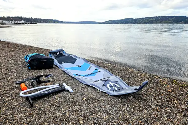 The Hydrus Paradise Touring Inflatable Paddle Board and its parts on dirt near water