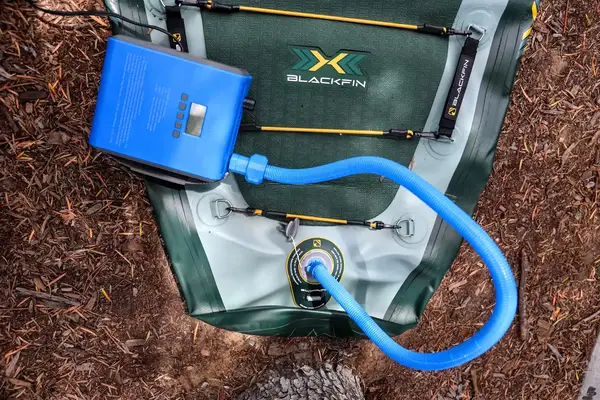 A pump attached to the iRocker BLACKFIN MODEL Inflatable Paddle Board