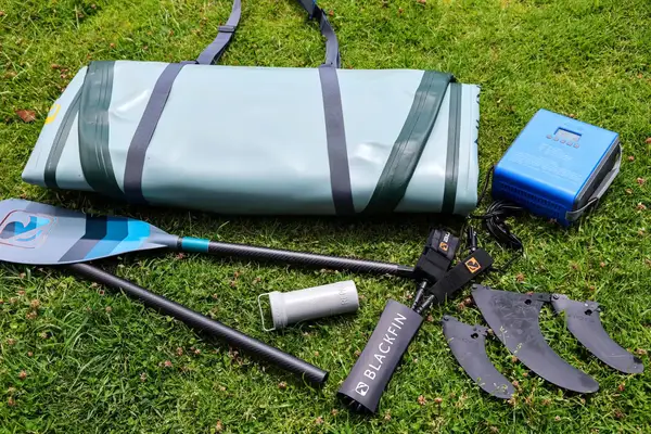 The iRocker BLACKFIN MODEL Inflatable Paddle Board parts on grass