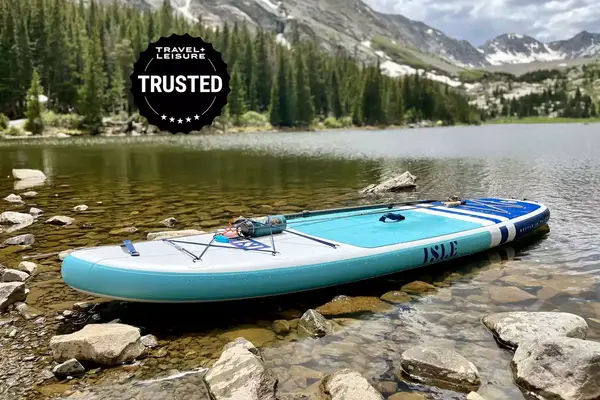 An Isle Pioneer Inflatable stand up paddle board floating in a lake