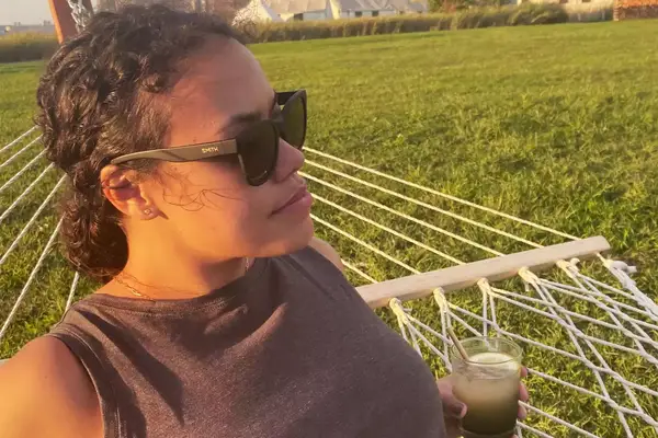 A person wearing the Smith Caper Sunglasses outside while lounging on a hammock