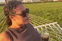 A person wearing the Smith Caper Sunglasses outside while lounging on a hammock