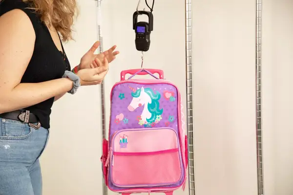 person weighing Stephen Joseph Classic Rolling Luggage