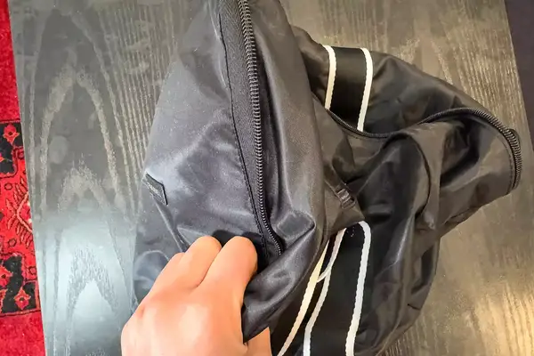 A hand holds a Paravel Fold-Up Bag