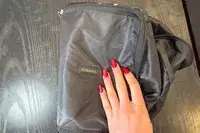 A hand holds a Paravel Fold-Up Bag