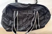 An empty Paravel Fold-Up Bag on a white bed