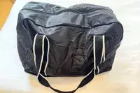 A closed Paravel Fold-Up Bag on a white bed